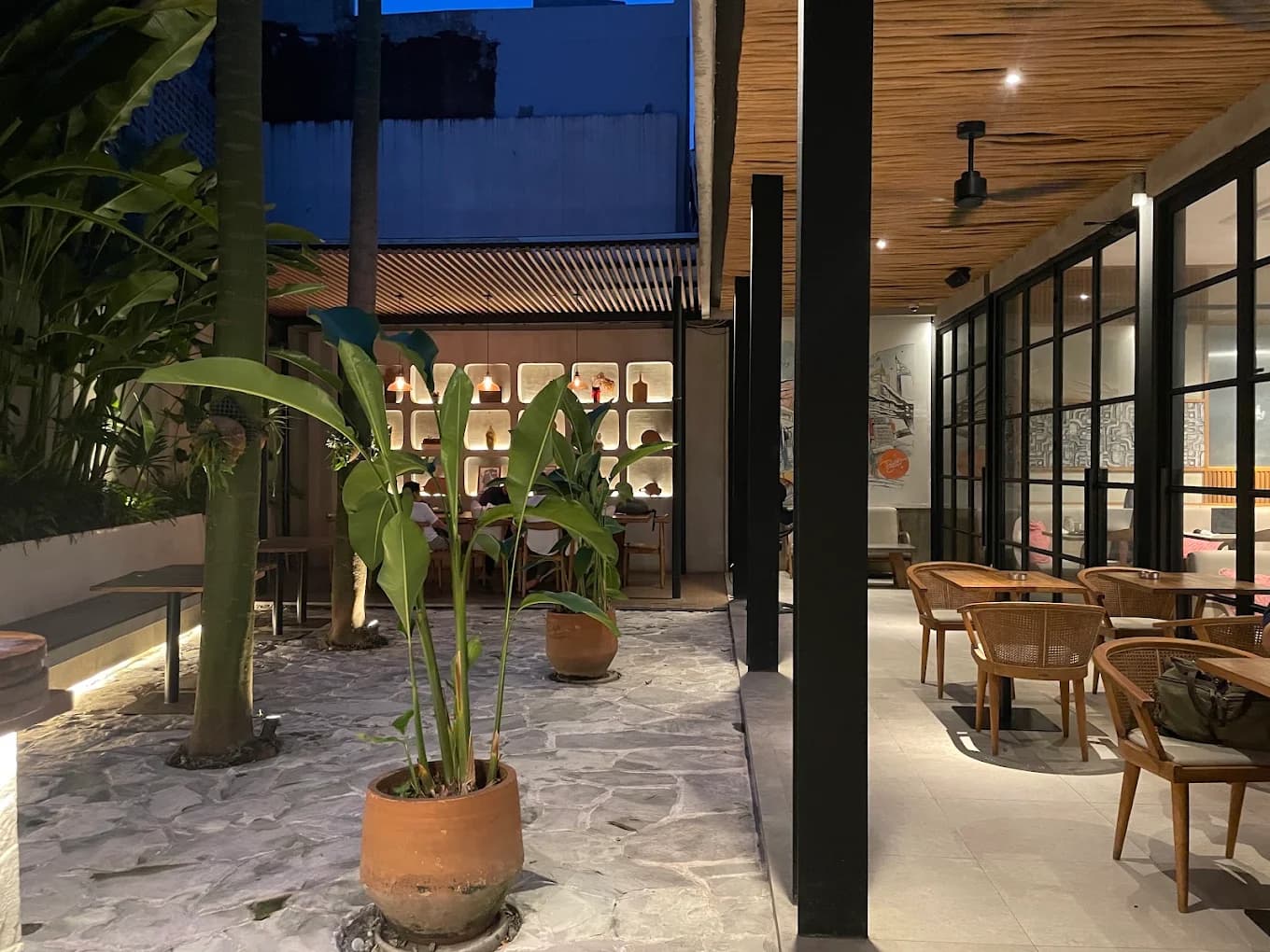 Area dalam The Post dengan courtyard hijau dan meja makan